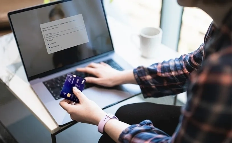 A consumer makes a card payment for an online purchase. Optimised payments help businesses increase approval rates first time 